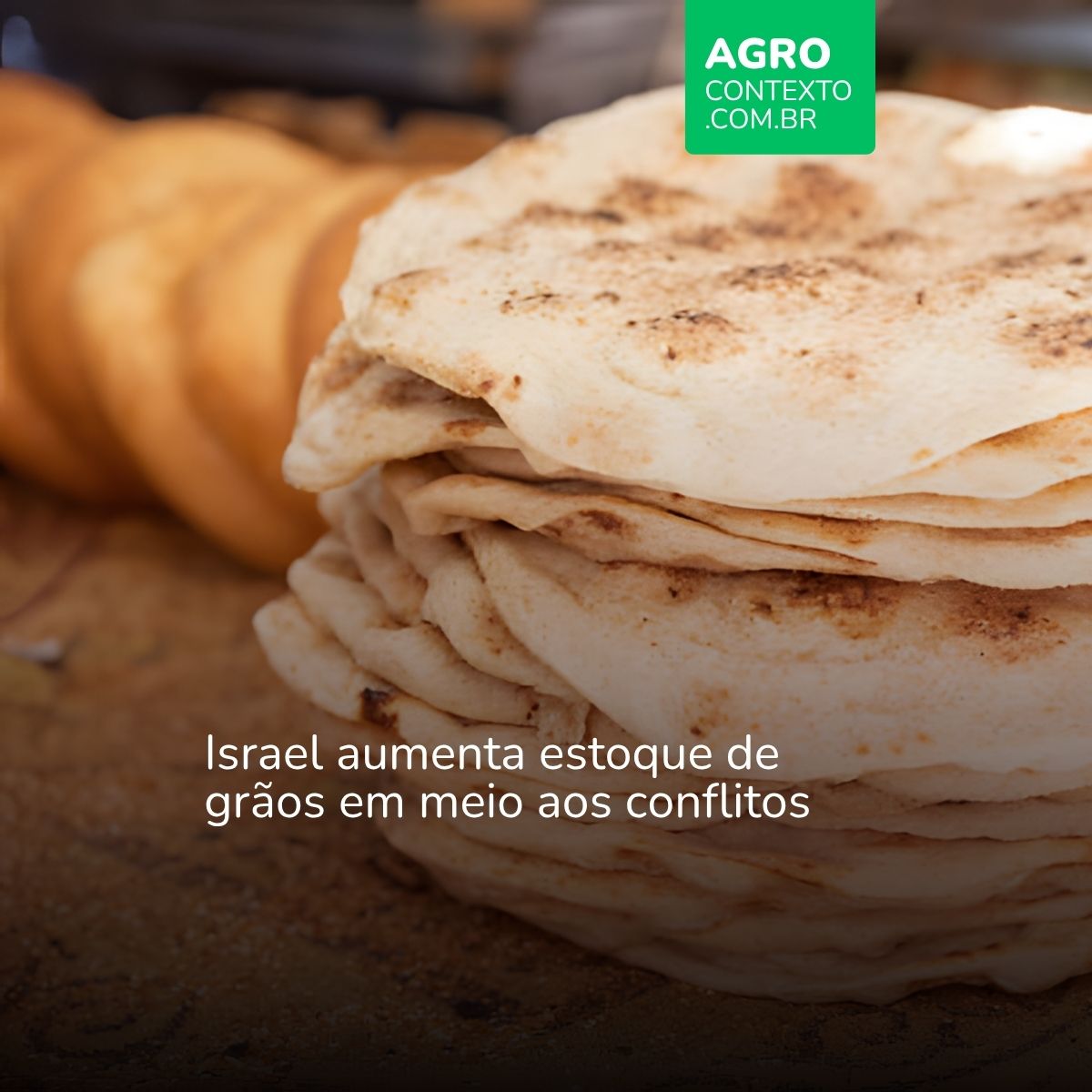 Pães pita empilhados em mesa coberta com toalha. texto: Israel aumenta estoque de grãos em meio aos conflitos